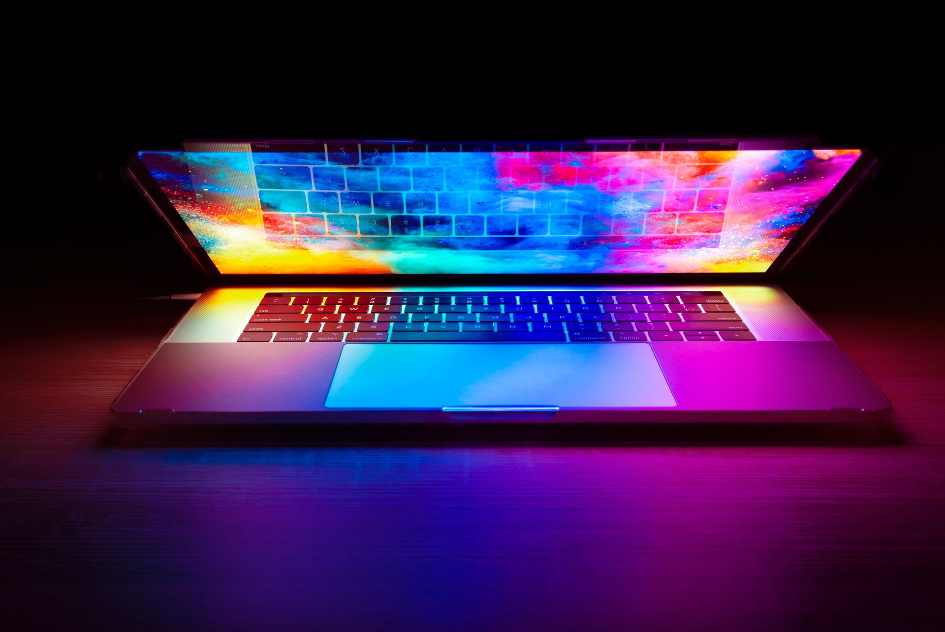 a shimmering, multi-colored laptop being opened in preparation to begin an e-learning course